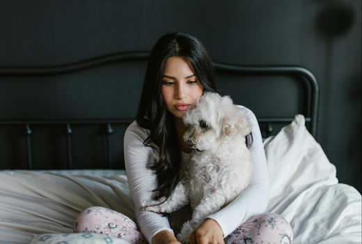 image-of-woman-holding-dog-in-bed